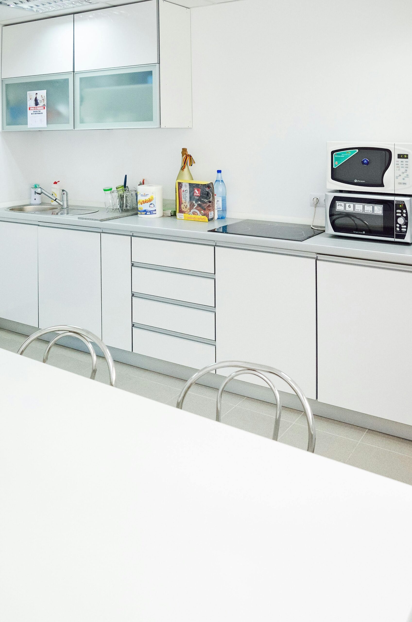 A sleek white kitchen interior featuring modern appliances and minimal design.